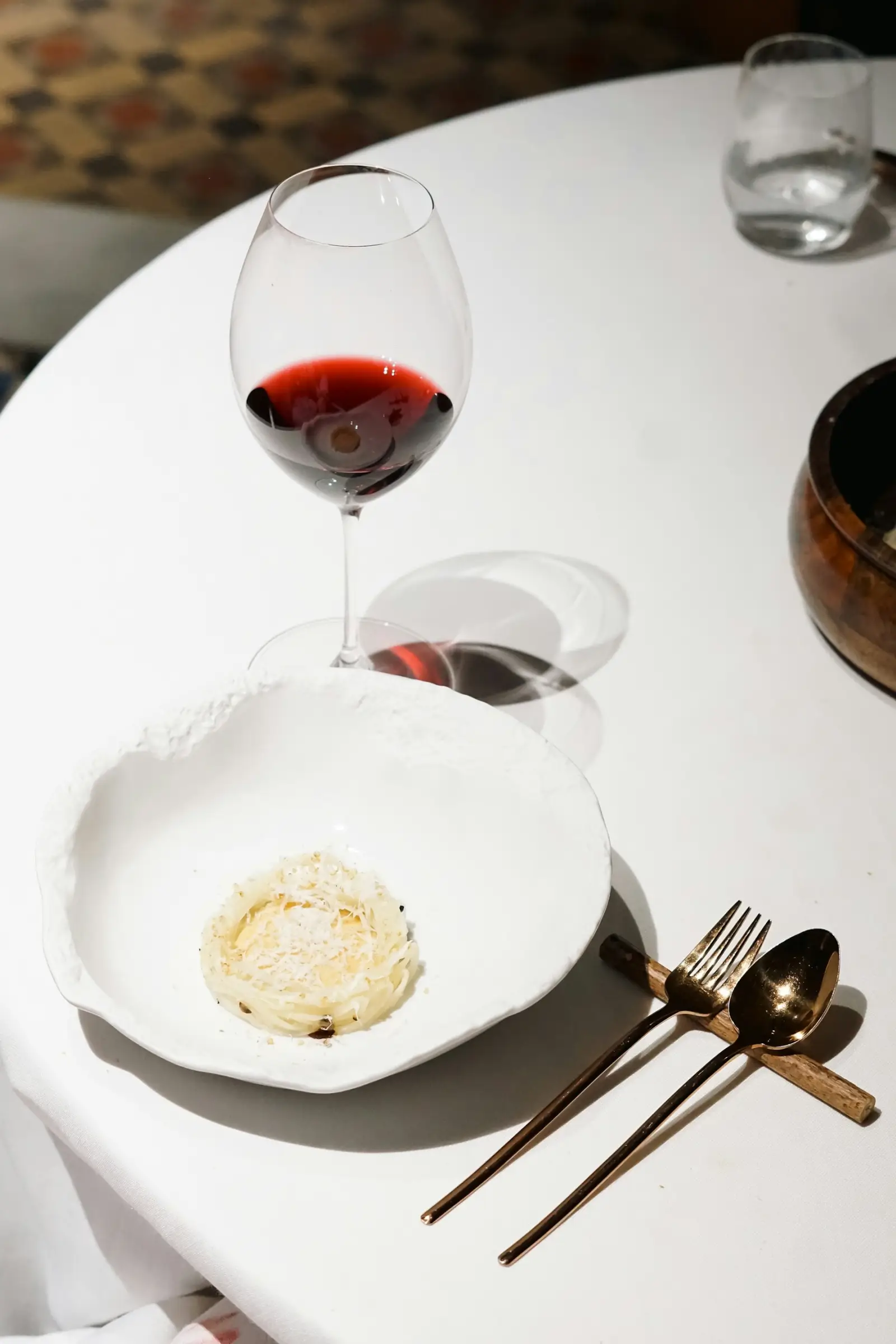 Mesa con plato y copa de vino (foto ilustrativa)